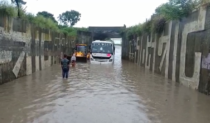 bus stuck underpass, passengers troubled, JCB helped